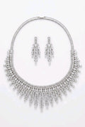 Grand Fringe Bib CZ necklace and chandelier earrings flat lay on white background