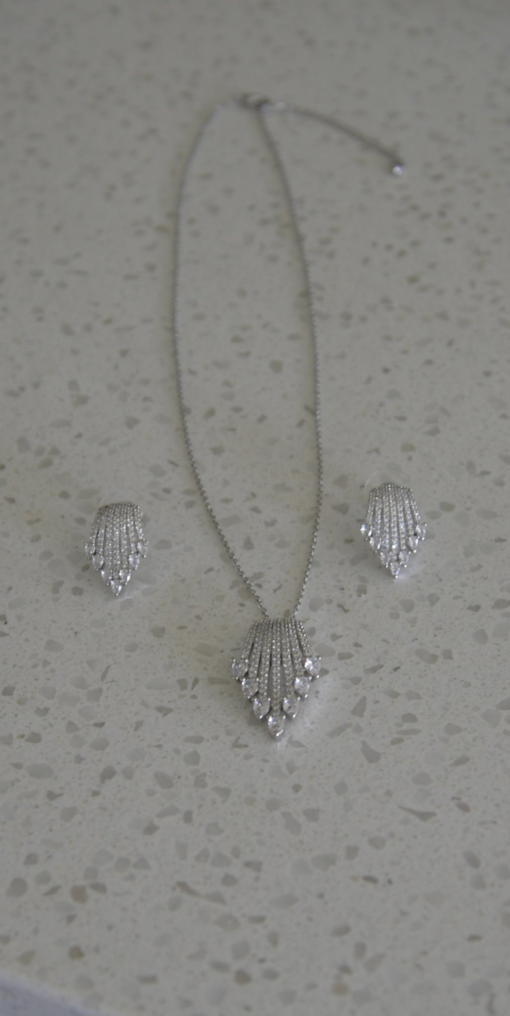 Real photo of Art Deco Fan CZ pendant necklace and earring set on marble surface