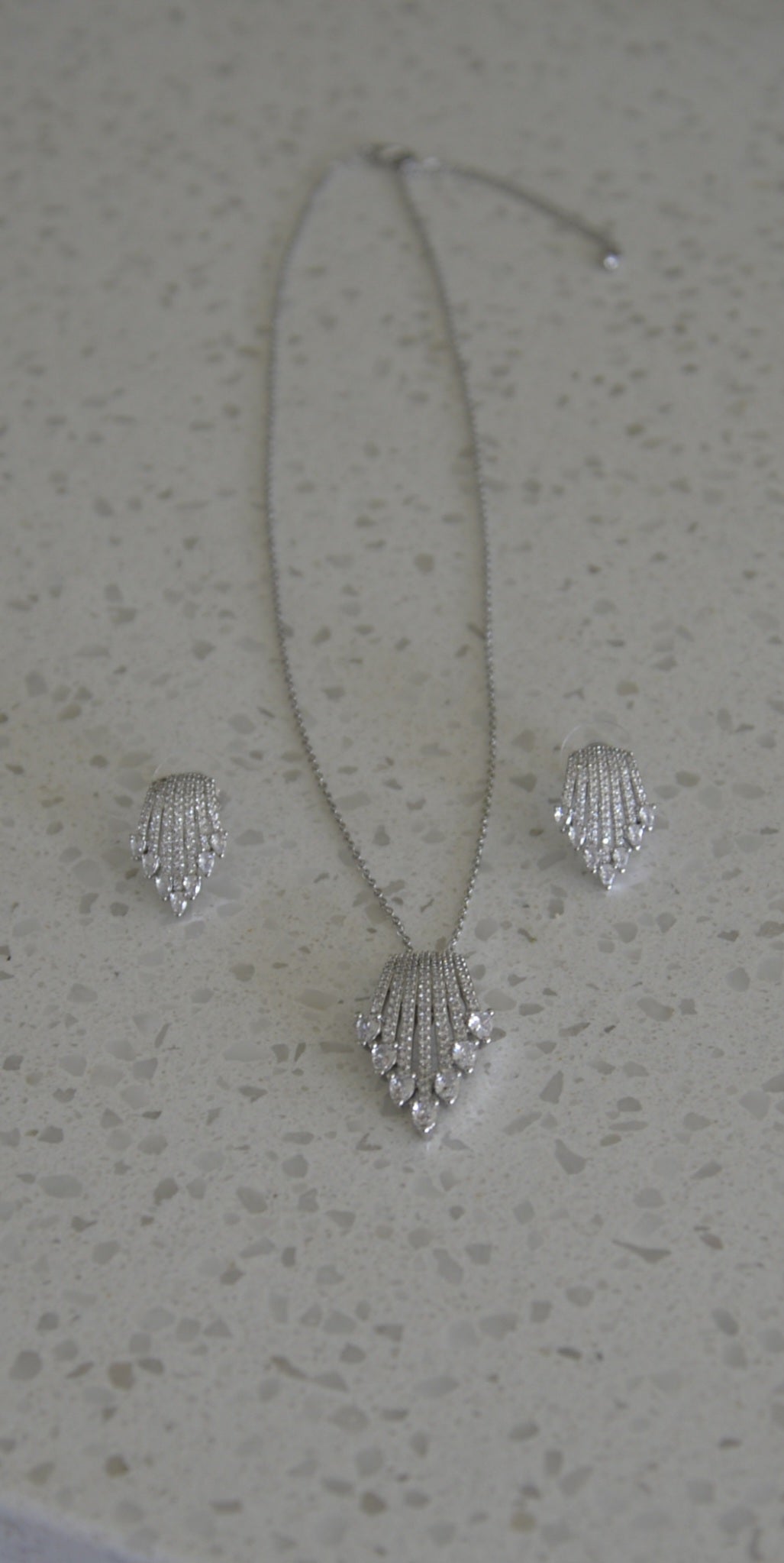 Real photo of Art Deco Fan CZ pendant necklace and earring set on marble surface