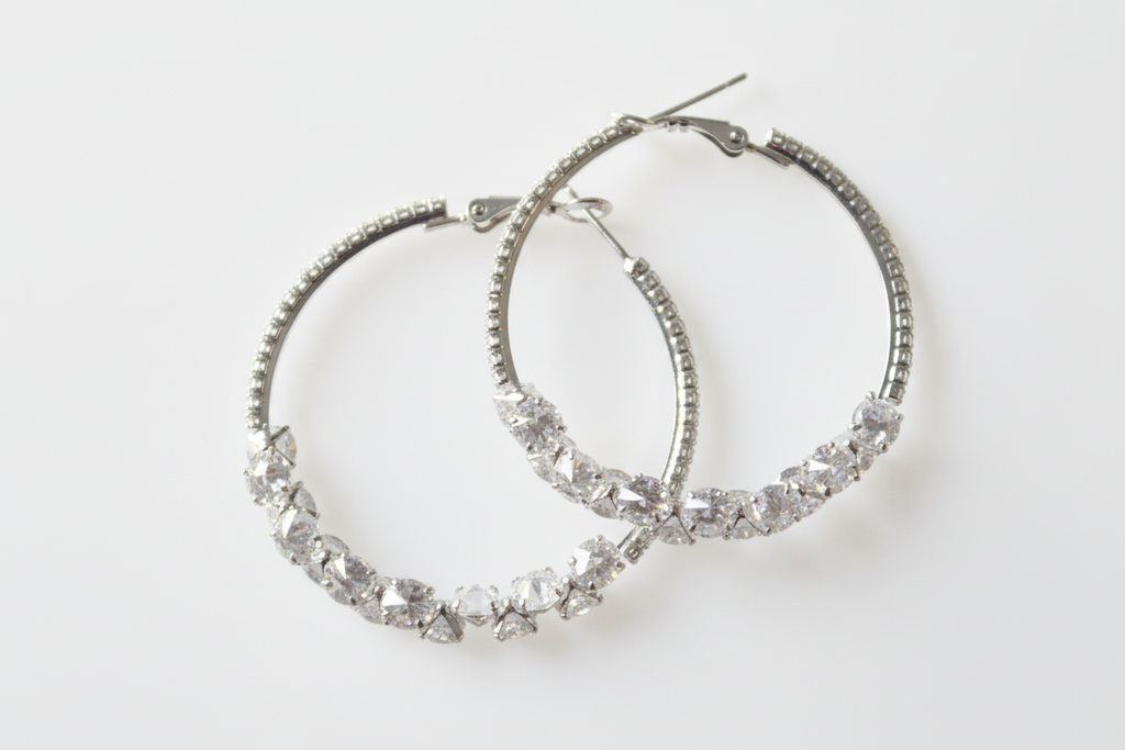 Cubic zirconia cluster hoop earrings on white background