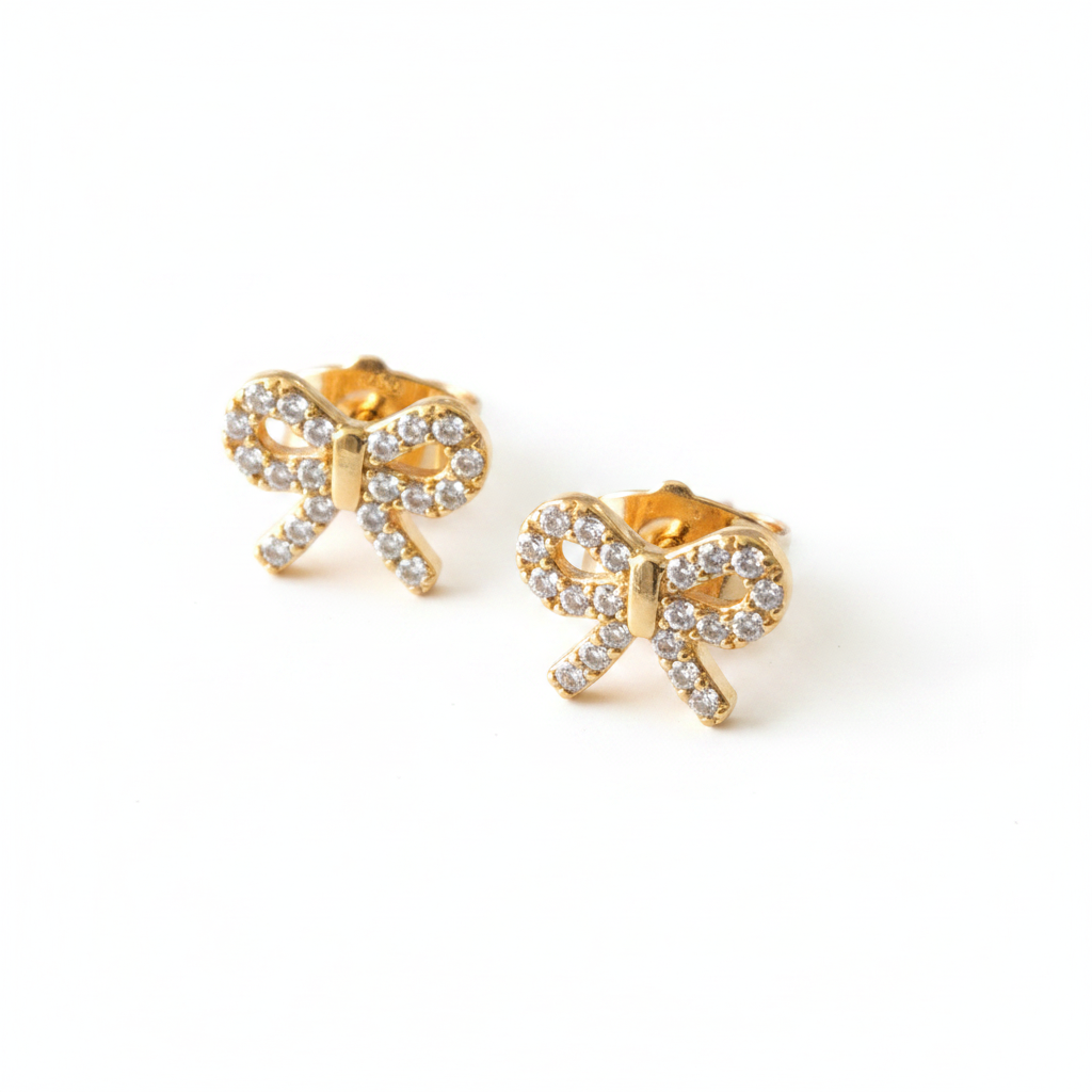 Cubic zirconia bow stud earrings in gold-tone angle view on white background